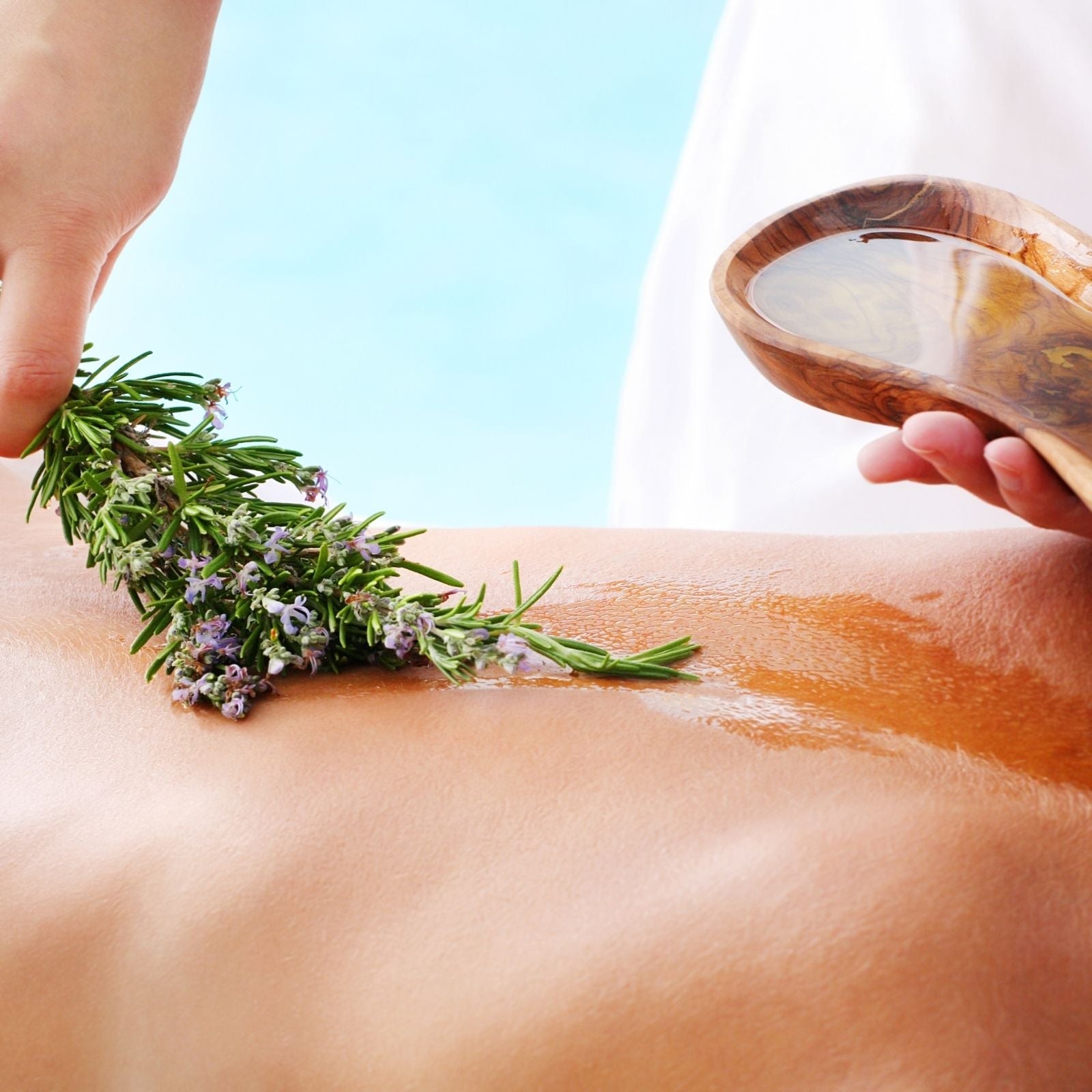 Wellness-Massage mit naturreinem Öl und frischem Rosmarinzweig auf dem Rücken – Sinnbild für natürliche Hautpflege und aromatische Entspannung