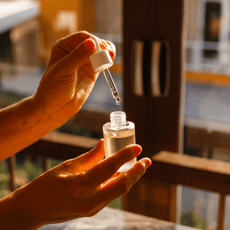 Anwendung von ätherischem Öl mit Pipette in einer Glasflasche – Sinnbild für Aromapraxis und naturreine Pflege.