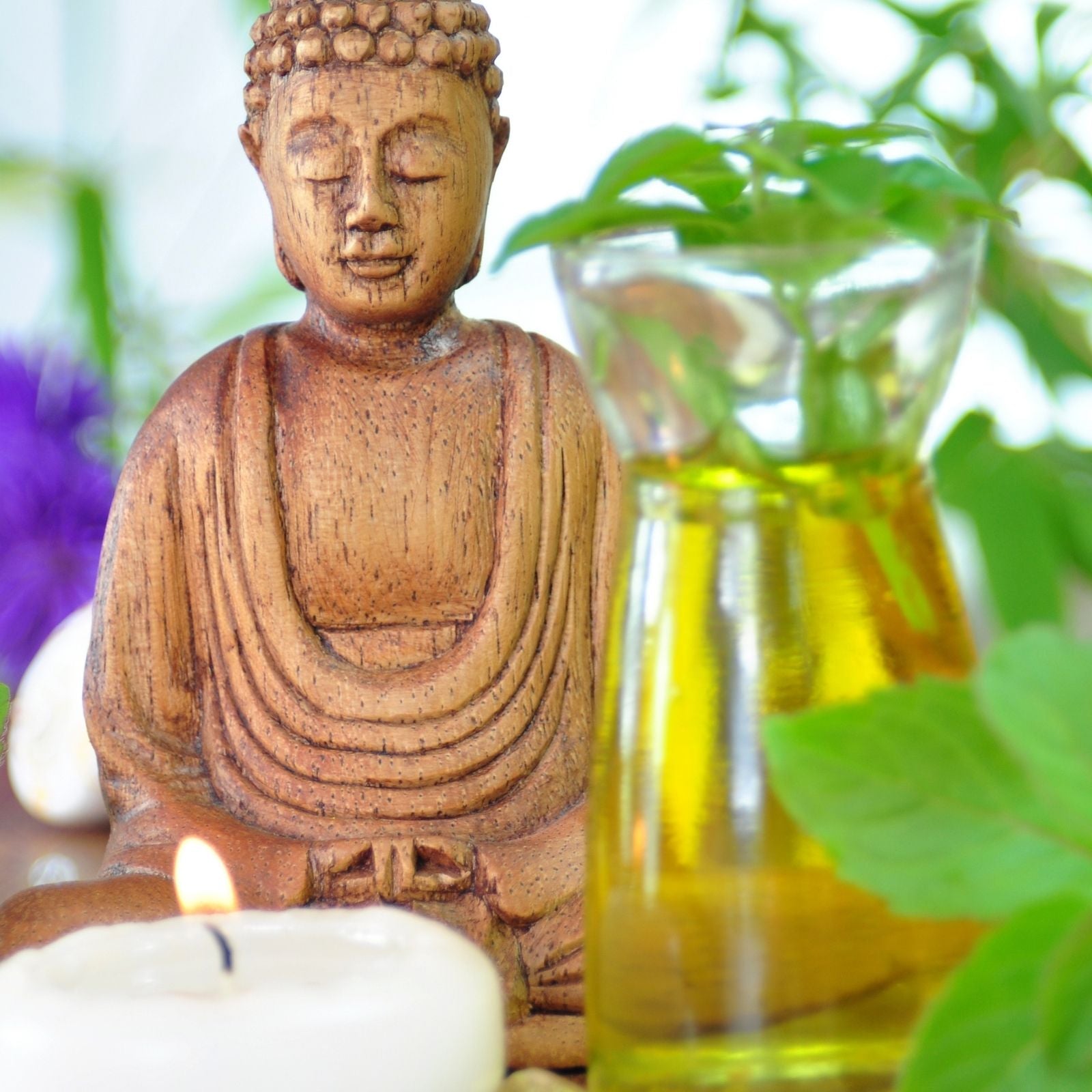 Buddha-Statue mit ätherischem Öl, Kerze und frischen Kräutern – Symbol für Achtsamkeit, Naturkraft und die harmonisierende Wirkung der Aromatherapie