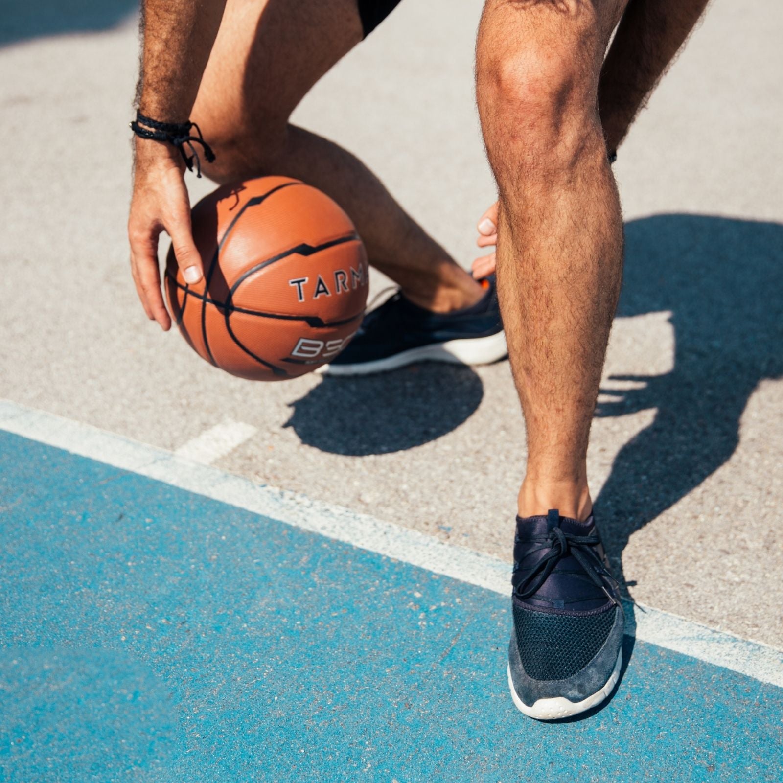 Mann mit blauen Turnschuhen beim dribbeln mit Basketball