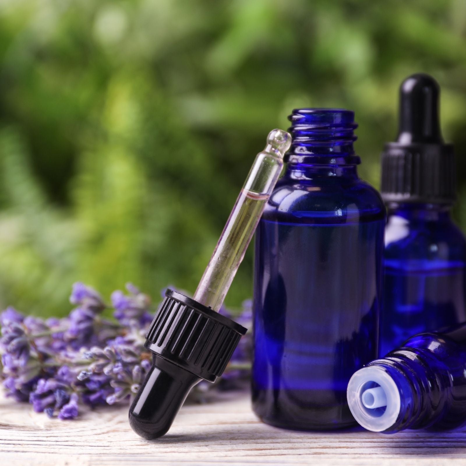 Blaue Tropfflaschen mit ätherischem Öl und Lavendel – Symbol für Reinheit, Natur und hochwertige Aromapflege.