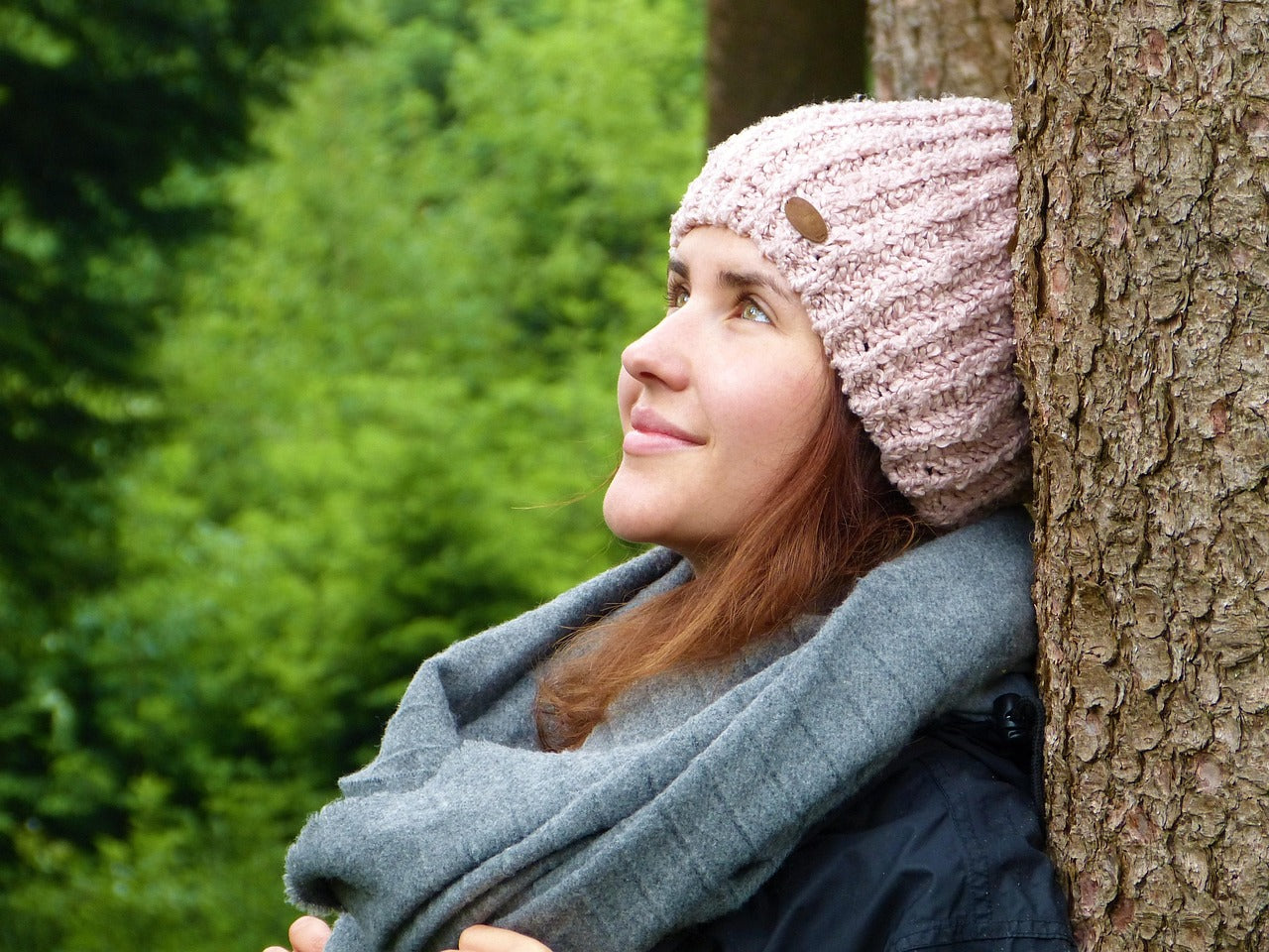 Frau lehnt sich vertrauensvoll an einen Baum und blickt nach oben – Ausdruck von Achtsamkeit, Geborgenheit und Naturverbundenheit mit ESSENCE-PUR (Foto: Silvia Rita, Pixabay)