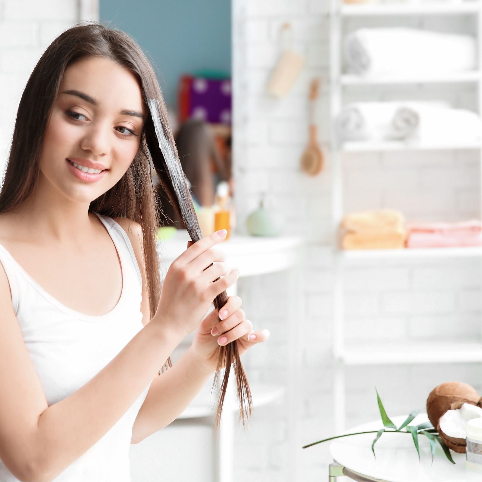 Frau trägt Kokos Öl in die Haarspitzen auf – natürliche Haarpflege im Bad.