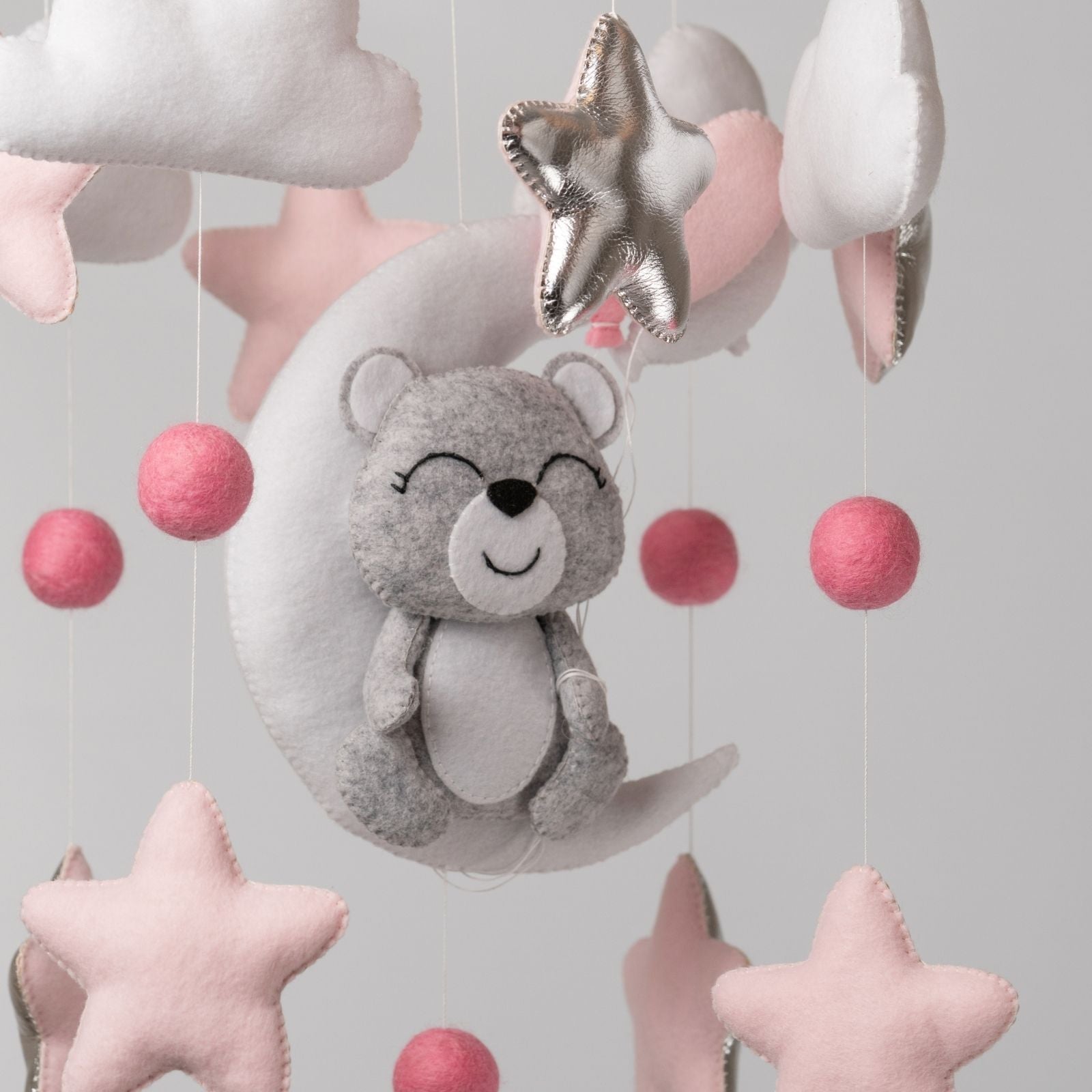 Weiches Mobile mit lächelndem Kuschelbär, rosa Sternen und Mond – liebevoller Begleiter im Kinderzimmer.