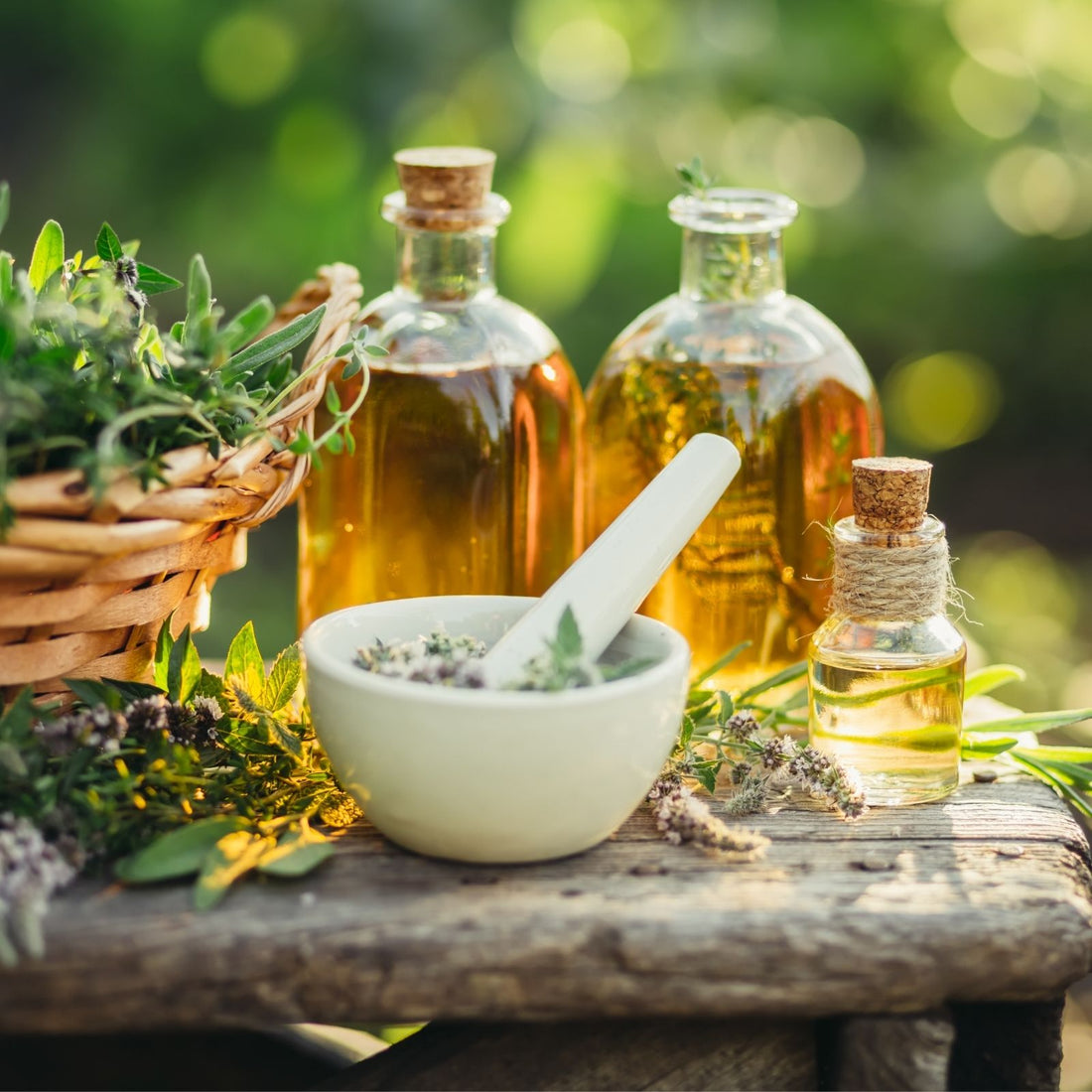 Frische Kräuter und naturreines ätherisches Öl auf einem Holztisch – Symbol für die handwerkliche Herstellung und die Kraft der Pflanzenwelt