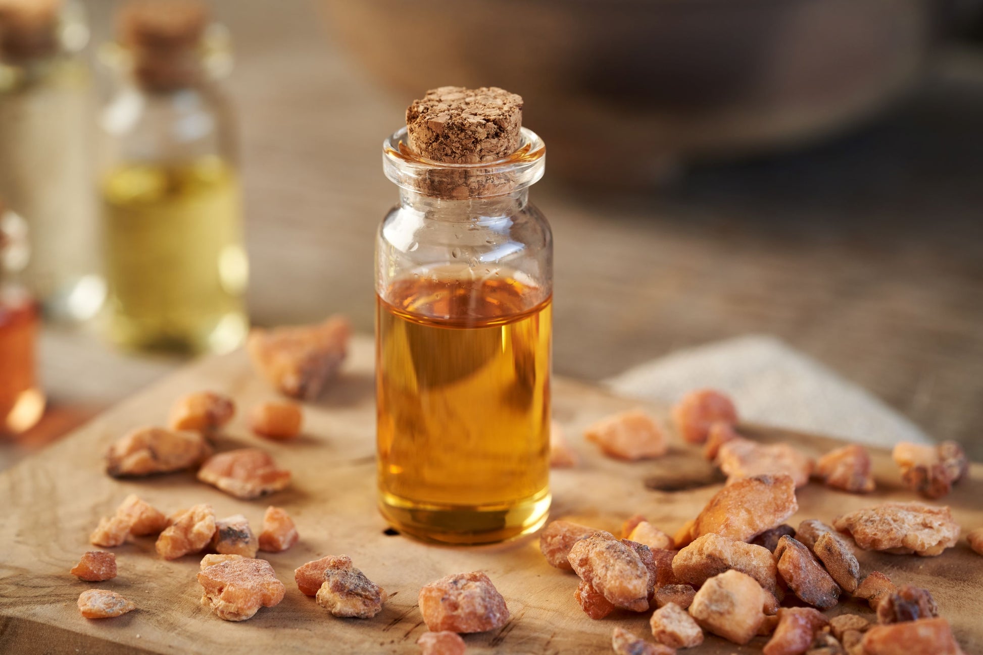 Styraxharz und ätherisches Styraxöl (Liquidambar styraciflua L.) – traditionelles Harz in Stücken und goldenes Öl in Glasflasche.