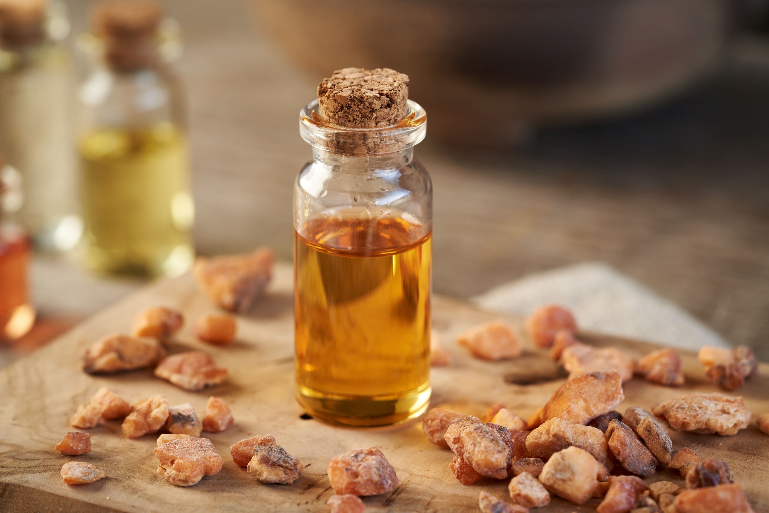 Styraxharz und ätherisches Styraxöl (Liquidambar styraciflua L.) – traditionelles Harz in Stücken und goldenes Öl in Glasflasche.