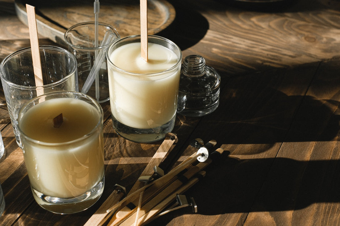 DIY-Citronella-Kerzen in Gläsern mit Dochten, vorbereitet auf einem Holztisch – natürliche Mückenabwehr mit ätherischen Ölen