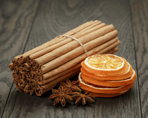 Bündel Zimtstangen mit getrockneten Orangenscheiben und Sternanis – traditionelle Verwendung von Zimt in Duft- und Gewürzmischungen.