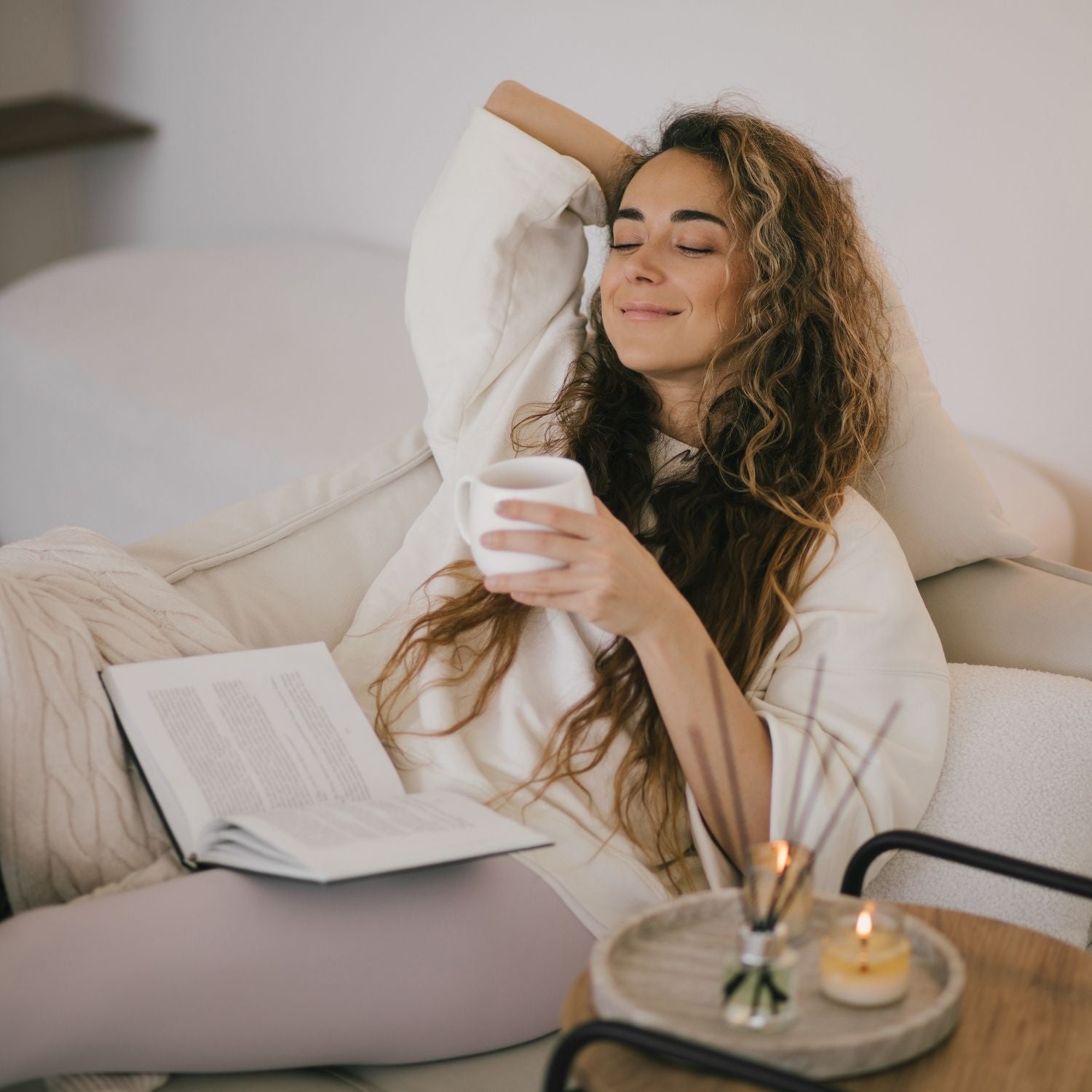 Entspannte Frau zuhause mit Duft-Diffusor und Kerzen – sanfte Aromatherapie im Alltag von ESSENCE-PUR