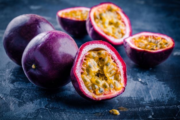 Reife Maracuja beziehungsweise Passionsfrucht mit geöffneter Frucht und exotischem Fruchtfleisch – Ursprung des kaltgepressten Maracujaöls bio