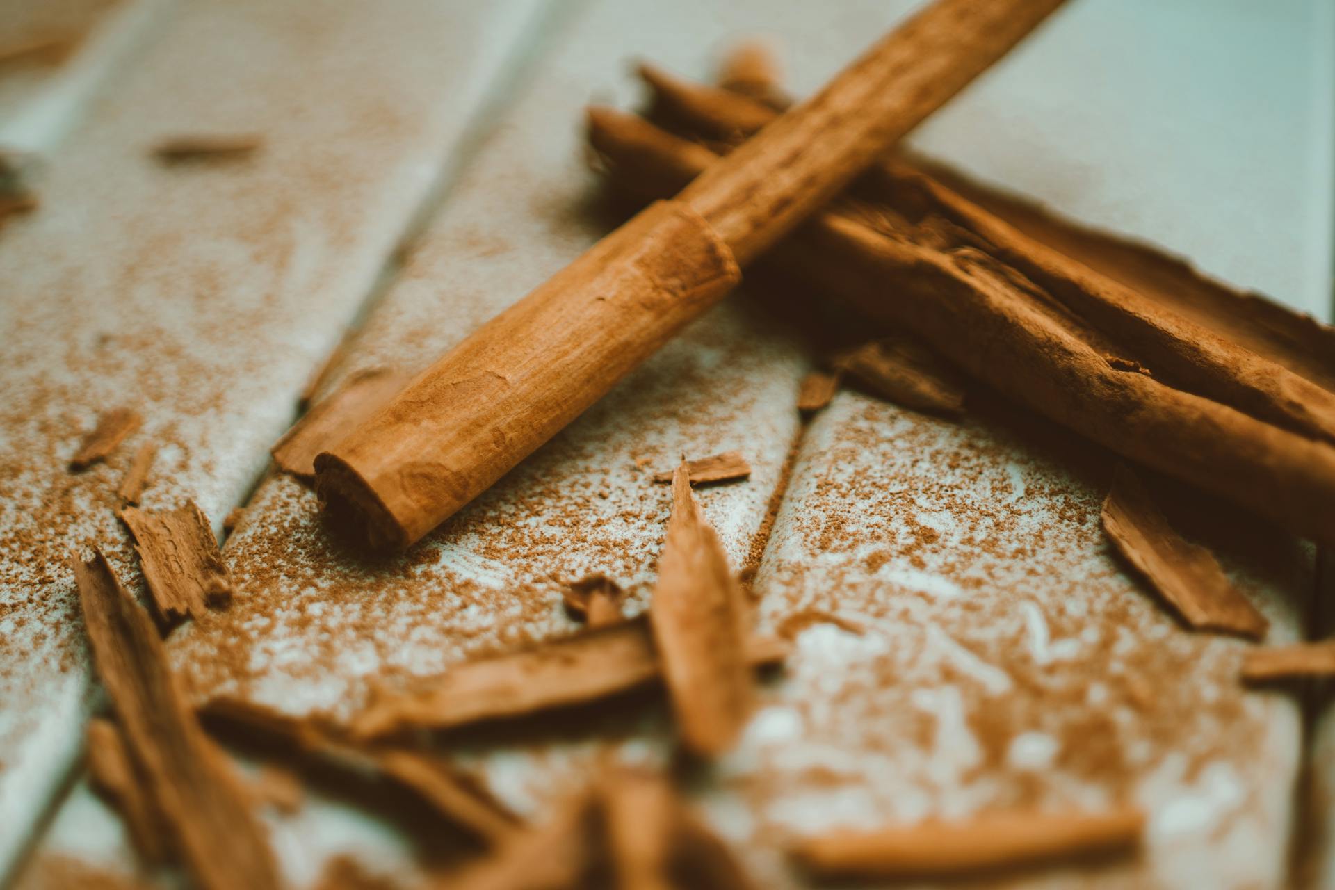 Detailaufnahme von Zimtstangen und Zimtpulver mit Holzsplittern – Sinnbild für die natürliche Verarbeitung und den intensiven Duft von Zimtöl.