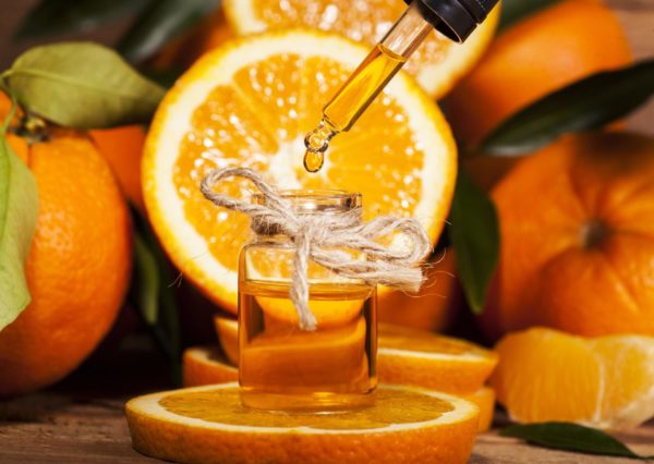Orangenöl mit aufgeschnittener Orange zur Gewinnung von Organge süß bio (Orangenöl)