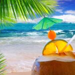 Erfrischender Tropenmoment am Meer: Karibische Strandkulisse mit Kokosnussdrink, Zitrusfrucht und Palmen – inspiriert von der Duftmischung „Caribean Paradise“